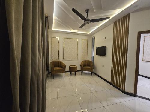 a waiting room with chairs and a ceiling fan at S H Residence & APARTMENTS in Mūsapur