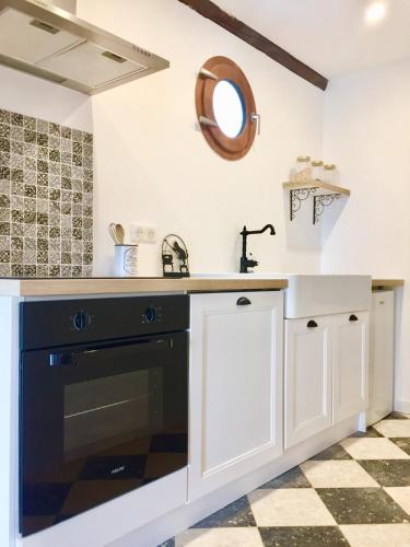 Il comprend une cuisine équipée d'un évier et d'un lave-vaisselle noir. dans l'établissement Villa Charme avec Piscine privée au coeur des Vignes, à Quarante