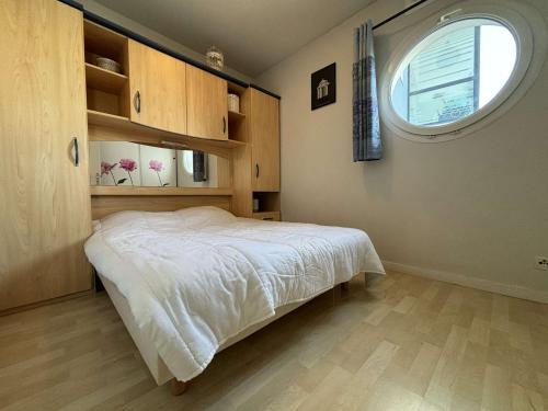 - une chambre avec un lit et une fenêtre ronde dans l'établissement Appt 2 pièces LA ROCHELLE - LR050-A16, à La Rochelle