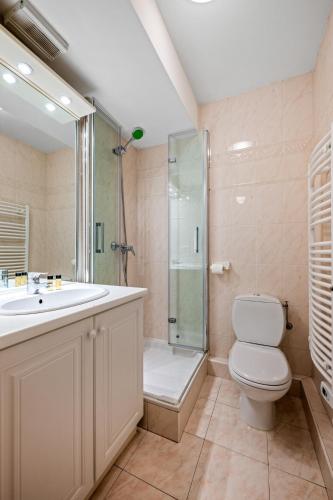 une salle de bain avec une douche, des toilettes et un lavabo dans l'établissement Admiral Plaza, appartement 1 chambre en centre ville, parking & accès plage, à Menton