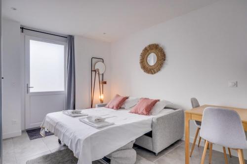 - une chambre blanche avec un lit et des oreillers roses dans l'établissement Superbe appartement sur les quais de Bordeaux, à Bordeaux