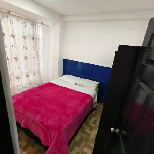 a bedroom with a bed with a red blanket at Rolling rosado in Funza