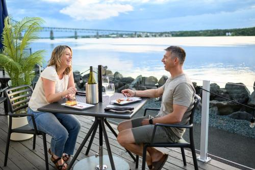a man and woman sitting at a table on a balcony at Rodd Miramichi in Miramichi