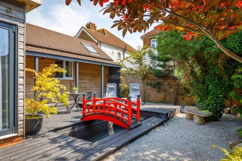 a red bridge on a deck in front of a house at The Artists Studio - With Unique Japanese Garden in Hove