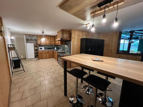 une grande cuisine avec une table et des chaises en bois dans l'établissement Rigolet Maison en Ville avec Piscine Intérieure, à Contres