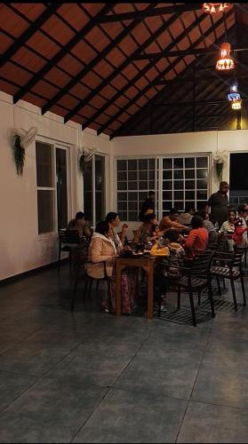 马迪凯里The Caligo resort coorg的一群人坐在一张桌子旁