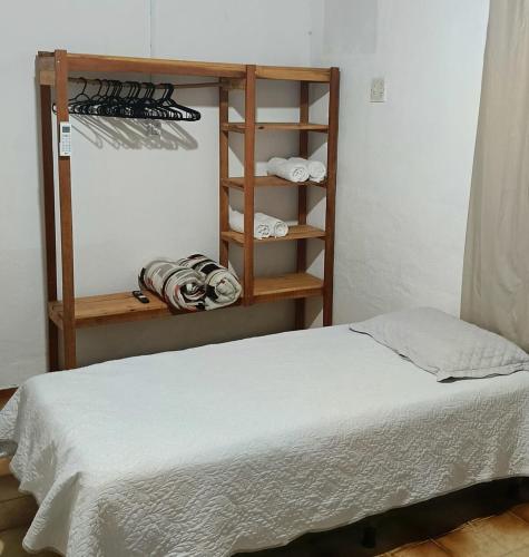 a bedroom with a bed and a shelf with towels at Casa na Região Central in Cuiabá