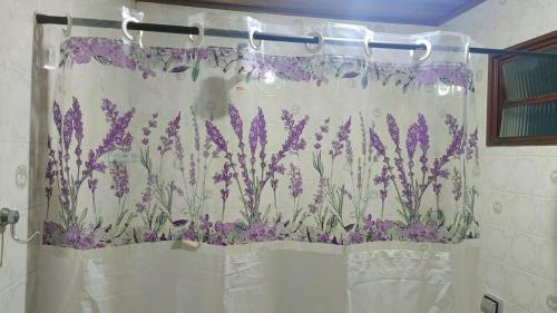 a shower curtain with purple flowers on it in a bathroom at Casa na Região Central in Cuiabá