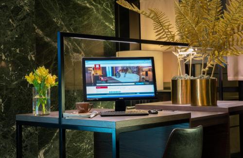 a desk with a computer monitor and a keyboard at Leonardo Hotel Madrid City Center in Madrid