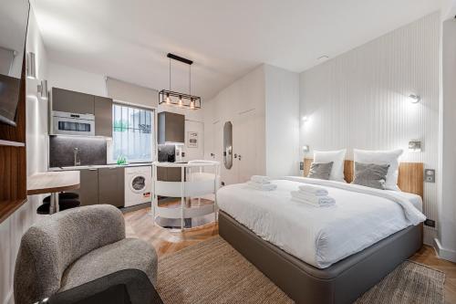 une chambre avec un lit et une chaise et une cuisine dans l'établissement Typical Parisian Apartment in Le Marais#4 pers, à Paris