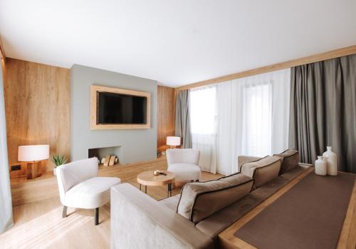 a living room with a couch and chairs and a tv at Valtur Cervinia Cristallo Ski Resort in Breuil-Cervinia