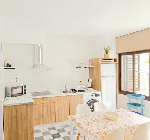 a kitchen with a table and chairs and a kitchen with white appliances at Apartamento Fortes in San José