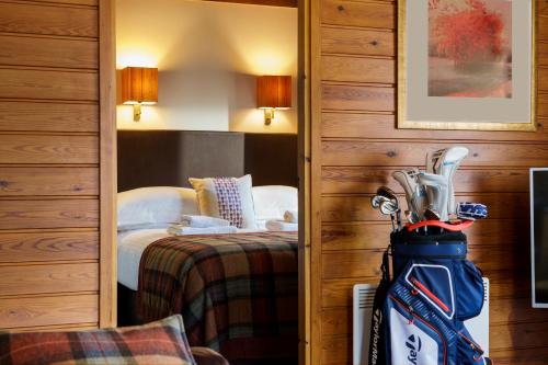 a hotel room with a backpack in front of a bed at Macdonald Spey Valley Resort in Aviemore