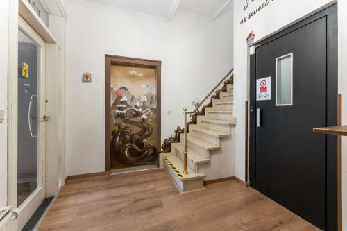 a hallway with stairs and a door with a painting on the wall at The Chocolate Suites in Bruges