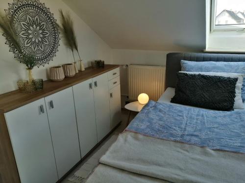 a bedroom with a bed and white cabinets and a window at Ferienwohnung Romanu in Winzeln