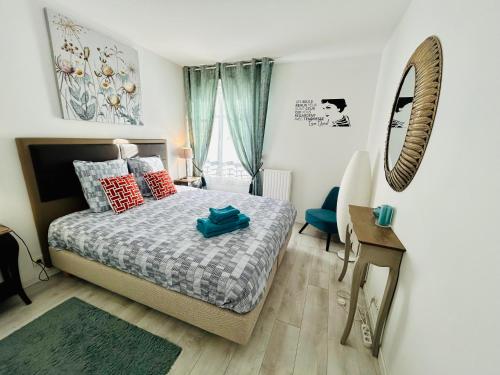 une chambre avec un lit et un miroir au mur dans l'établissement Le Danube Apartment F2 Disneyland, center ville, à Serris