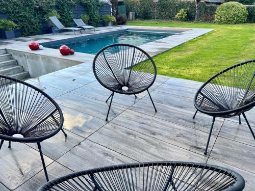 un groupe de chaises assises à côté d'une piscine dans l'établissement RESIDENCE AUX DEUX PICS - Tucou et Monné, à Bagnères-de-Bigorre