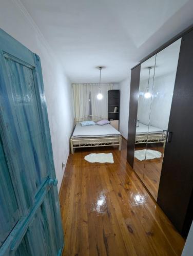 Un dormitorio pequeño con una cama y un espejo. en Eco loft, en Bishkek