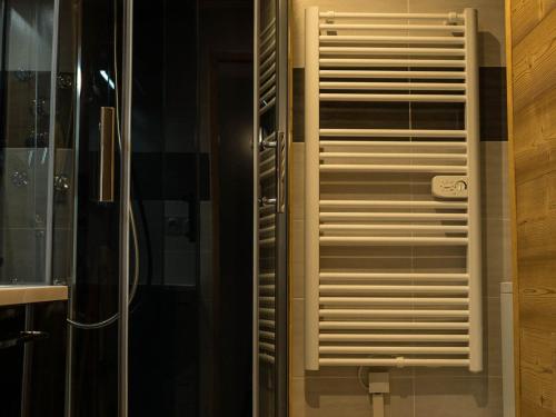 La salle de bains est pourvue d'une porte de douche en verre et d'une fenêtre. dans l'établissement Charmant Triplex 6 pers, 50m télécabine Sétaz, cœur de Valloire, balcon sud - FR-1-263-286, à Valloire