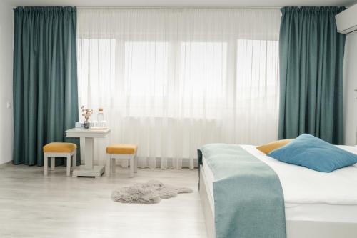 a bedroom with a bed and a table and a window at Sky Rooms in Sub Coastă