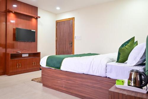 a bedroom with a large bed and a television at LeafyInn Premium 2BHK Apartment-Khanapara in Guwahati