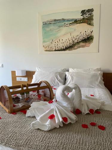 a bed with two swans and hearts on it at HOTEL BOUTIQUE VILAVELLA in O Grove