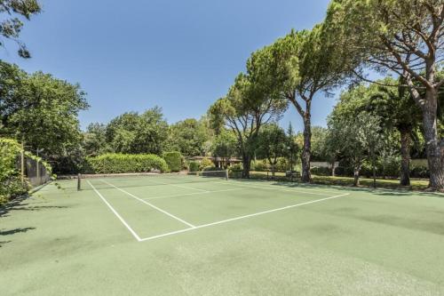 un court de tennis avec des arbres en arrière-plan dans l'établissement 7 bedrooms Villa in St Paul de Vence with 5000sqm, à Vence