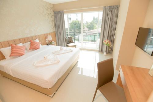 a bedroom with a large bed and a balcony at The Bedroom Ladprao 101 Bangkok - SHA in Bangkok