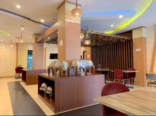 a restaurant with a counter with wine glasses on it at hotel parma paus in Sultan Syarif Kasim II International Airport