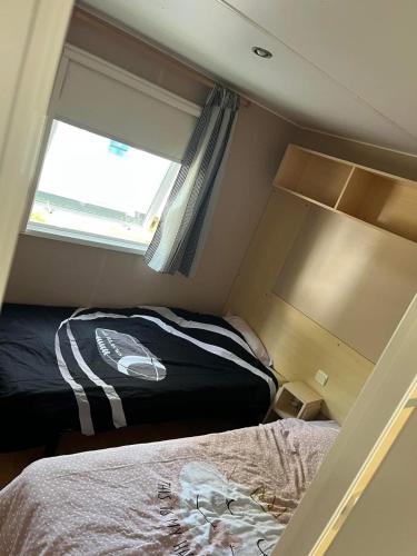 une petite chambre avec deux lits et une fenêtre dans l'établissement Mobil home, à Angles