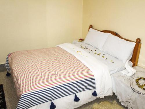 a bedroom with a bed with a black and white comforter at Hostel Nomad in Mirleft