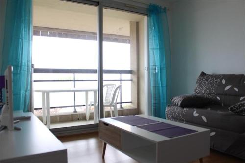 un salon avec un canapé et une grande fenêtre dans l'établissement Appt Studio cabine LA ROCHELLE - LR190-201, à La Rochelle