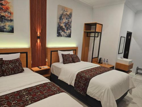 a hotel room with two beds in a room at Naraya Nusantara Resort & Kafe in Sepaku