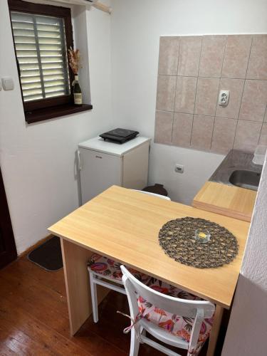 a small kitchen with a wooden table and a sink at Kutak Sreće in Vrdnik