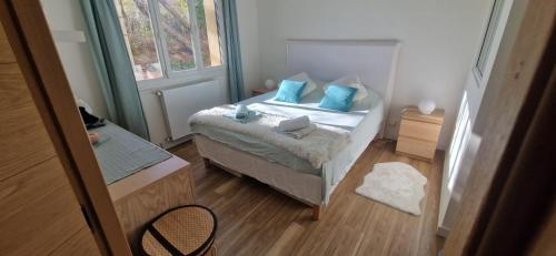 Cette petite chambre comprend un lit avec des oreillers bleus. dans l'établissement Lumineux et cosy T2 en centre ville, à Aix-en-Provence