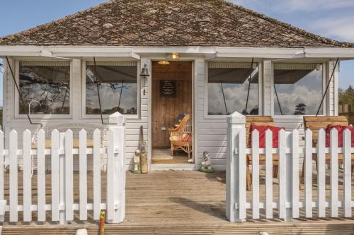 a small white house with a white picket fence at The Cricket Pavilion in Warham