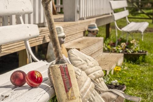 a statue of a baseball bat and two red balls at The Cricket Pavilion in Warham