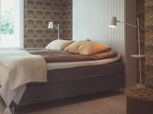 a bedroom with a bed in a room with a lamp at Folk och Fä in Grisslehamn