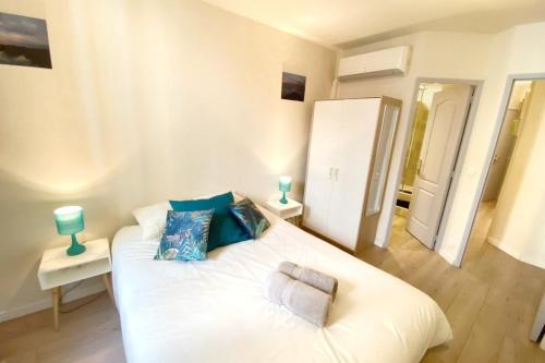 - un lit blanc dans une chambre avec deux lampes dans l'établissement 2 bedrooms 2 bathrooms 1 min Palais & beaches, à Cannes