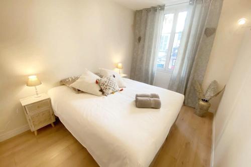 une chambre avec un grand lit blanc avec une fenêtre dans l'établissement 2 bedrooms 2 bathrooms 1 min Palais & beaches, à Cannes