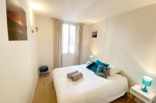 une chambre avec un lit blanc et une fenêtre dans l'établissement 2 bedrooms 2 bathrooms 1 min Palais & beaches, à Cannes