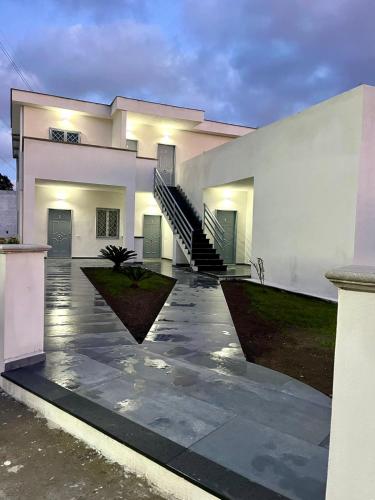 a large white house with a staircase in front of it at Dodi's house in Pozzuoli