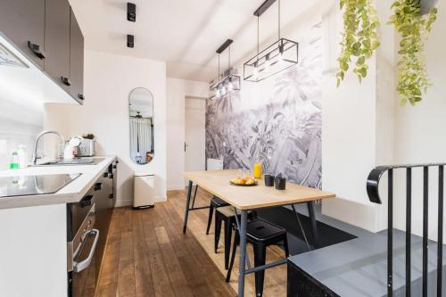 une cuisine avec une table en bois et une salle à manger dans l'établissement Appartement au coeur Paris 9 moulin rouge - FLAT-GUEST, à Paris