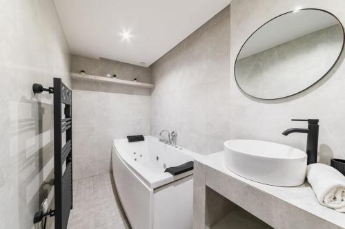 une salle de bain blanche avec un lavabo et un miroir dans l'établissement Appartement au coeur Paris 9 moulin rouge - FLAT-GUEST, à Paris