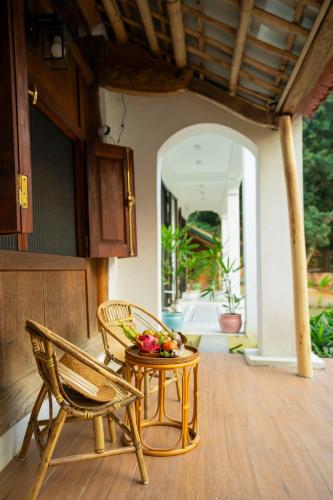 a table with fruit on it next to a chair at Charm Vân Long in Ninh Binh