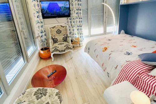 une petite chambre avec un lit et une table dans l'établissement Superbe Appartement ,Terrasse avec climatisation et parking payants, à Bagneux