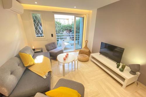 a living room with a couch and a flat screen tv at Renovated 2 bedrooms - Boulevard de la Croisette in Cannes