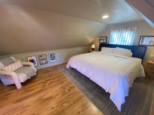 a bedroom with a large white bed and a chair at Big apartment by the Farmers market in Kitchener
