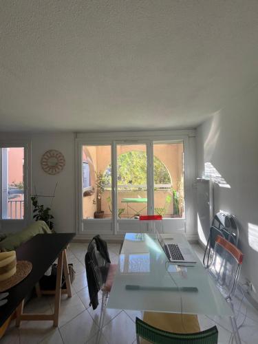 un salon avec une table avec un ordinateur portable dessus dans l'établissement Appt Lumineux, Terrasse Parking privé, à Montpellier