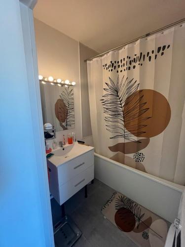 une salle de bain avec un rideau de douche et un lavabo dans l'établissement Appt Lumineux, Terrasse Parking privé, à Montpellier